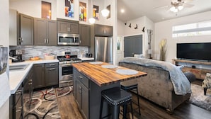 Una cocina moderna con una isla central, electrodomésticos integrados y un comedor.