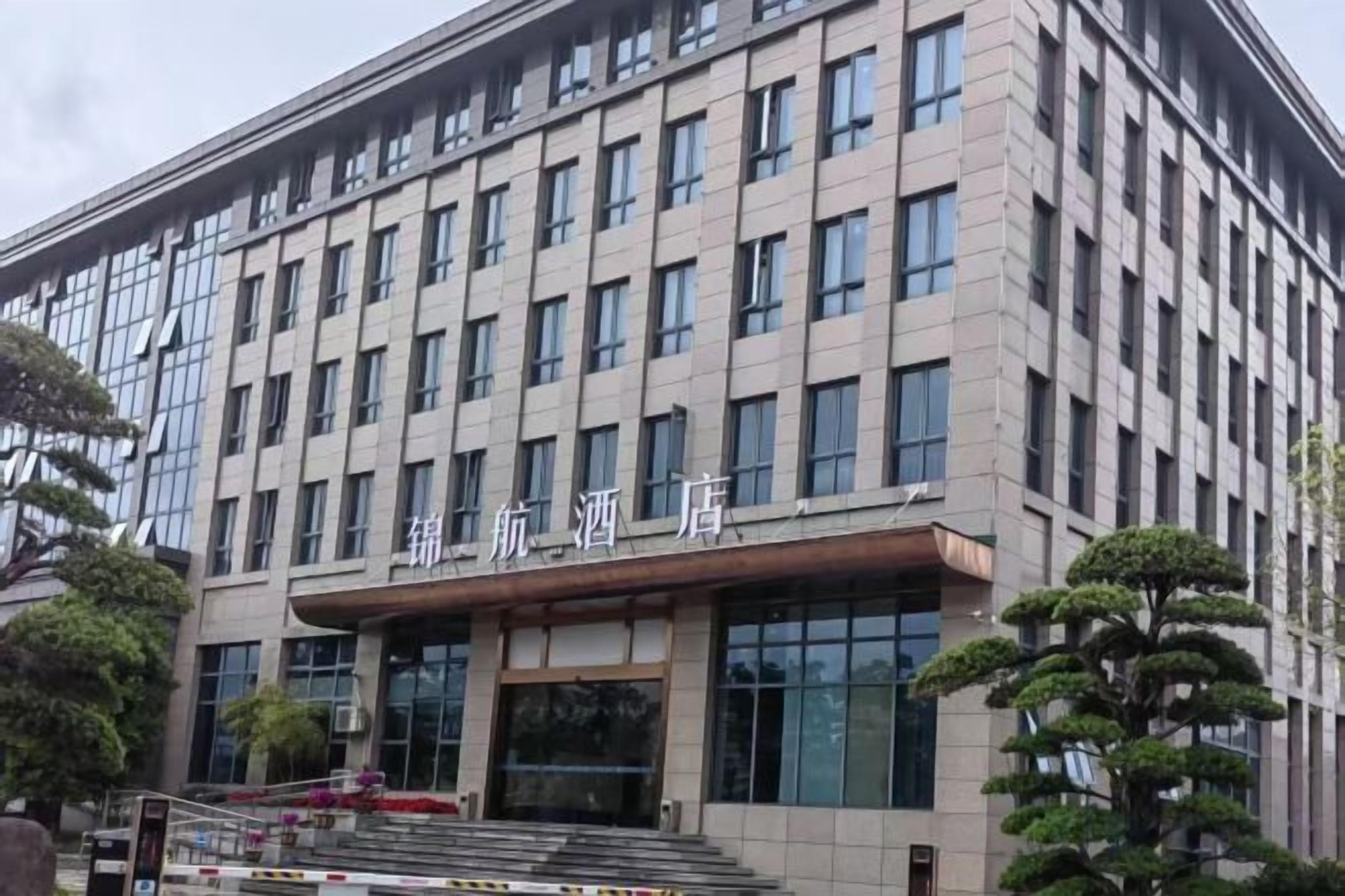 A multi-story building with a flat facade, large windows, and a sign with Chinese characters.