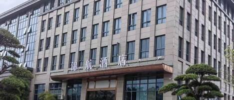 A multi-story building with a flat facade, large windows, and a sign with Chinese characters.