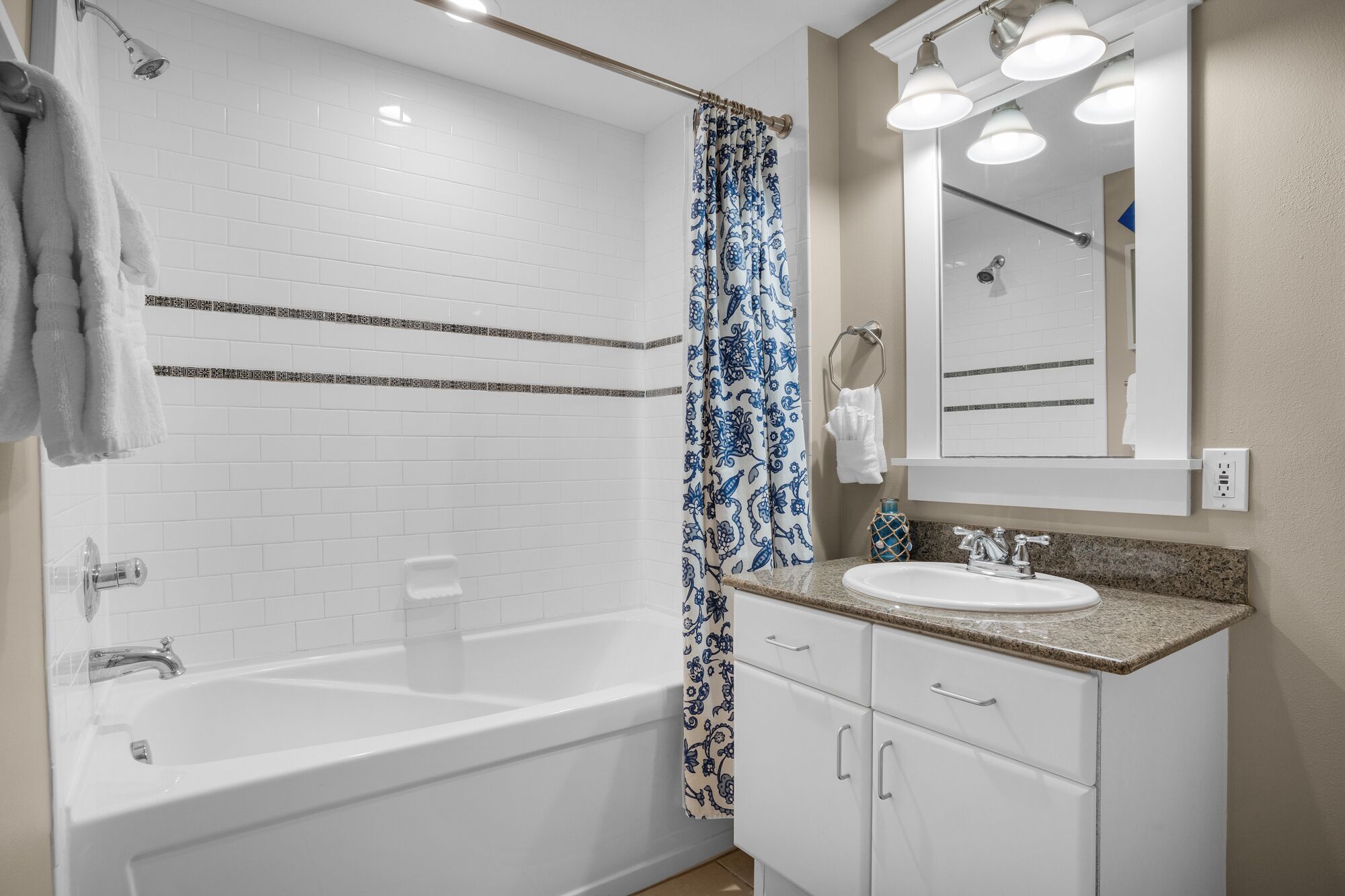 A modern bathroom with a bathtub, a shower, a sink, and a vanity.