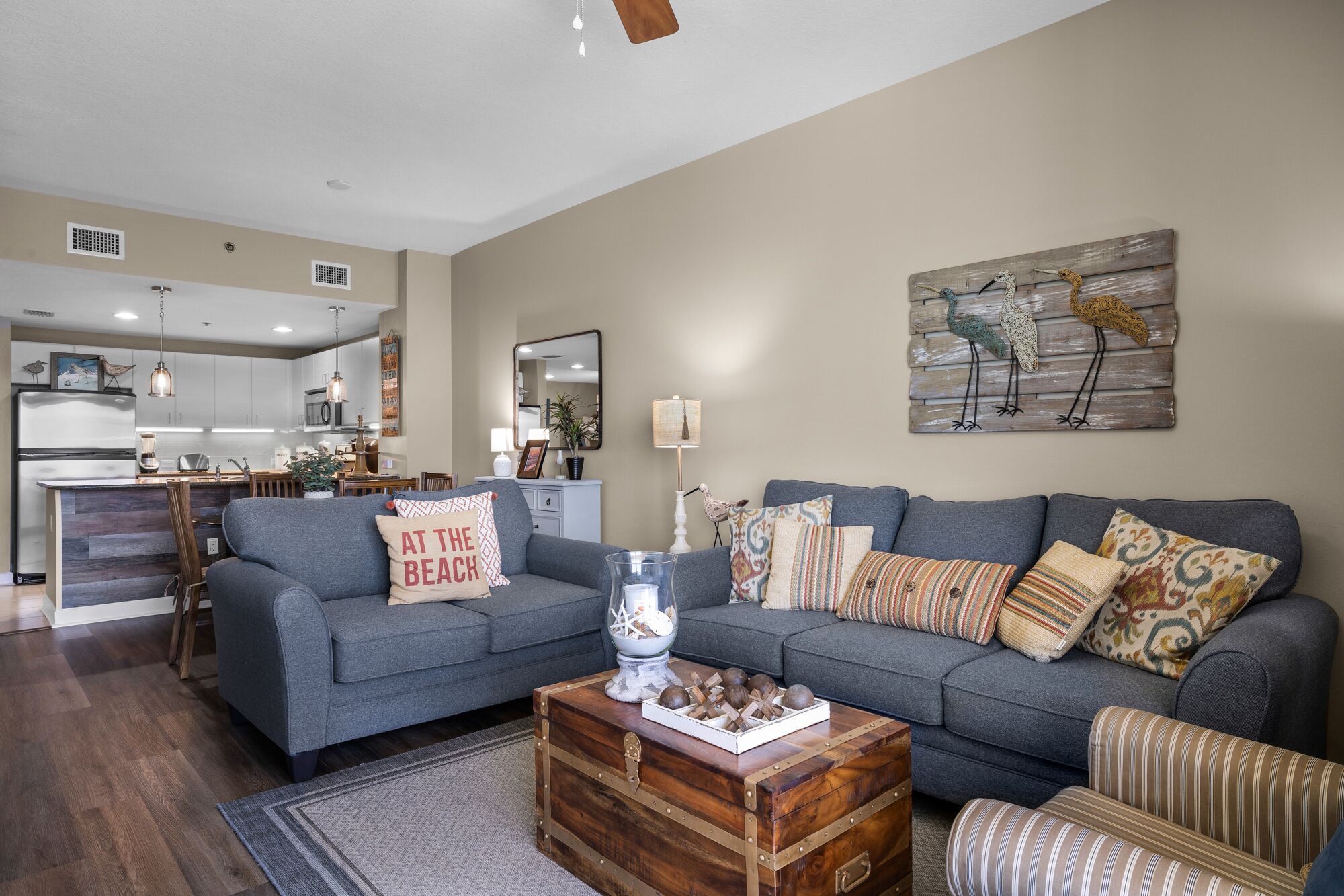 Ein modernes Wohnzimmer mit grauem Sofa, einem Holztisch und einem dekorativen Wandbild.