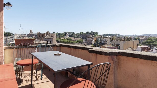 A rooftop terrace with a table and chairs, offering a view of a historic cityscape. - Spectacular attic with private terrace in central Rome - Wifi, Heating, A/C (Roma)