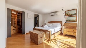 A bedroom with a wooden bed, a wicker chest, a wardrobe, and a dresser. - Spectacular attic with private terrace in central Rome - Wifi, Heating, A/C (Roma)