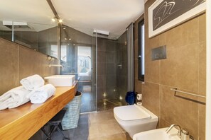 A modern bathroom with a glass shower enclosure, a wooden vanity with a mirror, and a white toilet.