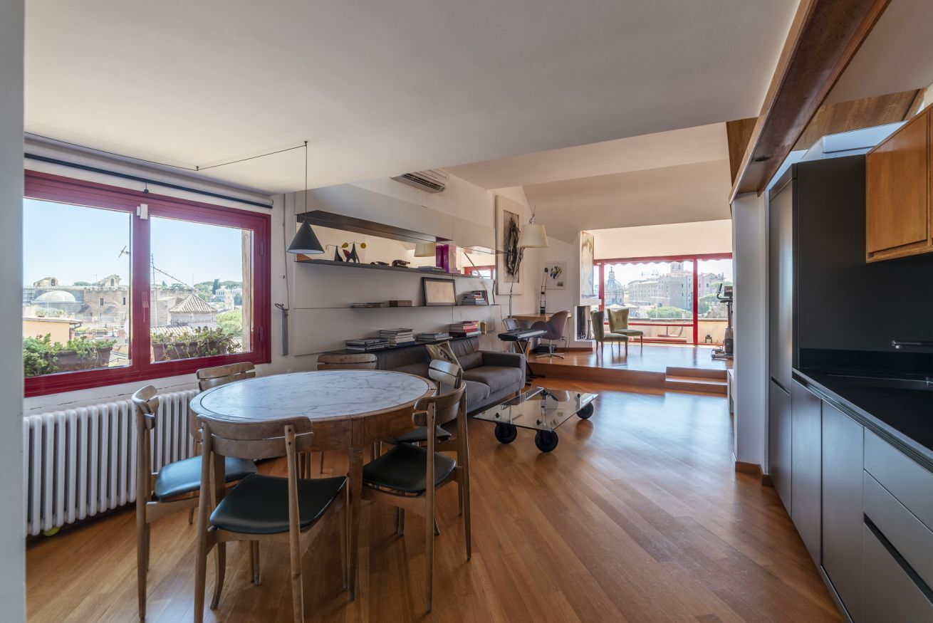 A modern apartment with a dining area, kitchen, and living space.