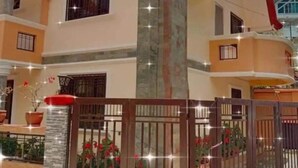 A multi-story house with a red roof, a stone pillar, and a gated entrance with potted plants. - My Home in Baguio City (Baguio City)