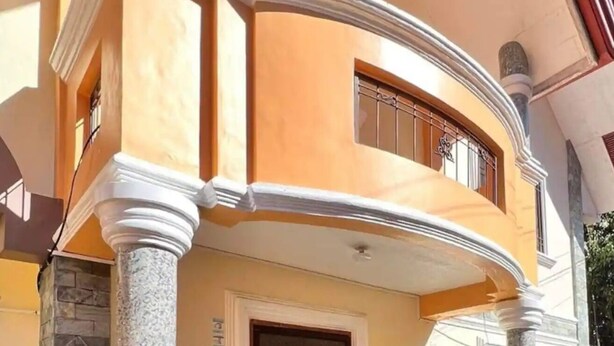 A corner of a building with a curved balcony, a door, and a window with a metal grille. - My Home in Baguio City (Baguio City)