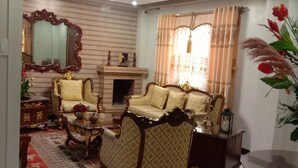 A traditional living room with a fireplace, ornate furniture, and a decorative mirror. - My Home in Baguio City (Baguio City)