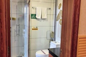 A modern bathroom with a glass shower enclosure, a white toilet, and a towel rack. - Junmei International Hotel (Jiangbin Cultural Square Branch) (Dahua)