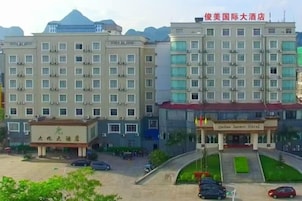 Un hotel con varios pisos, una entrada principal y una zona de estacionamiento.