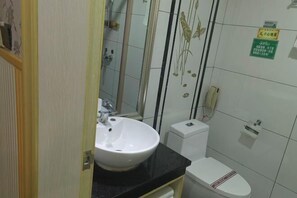 A bathroom with a white sink, toilet, and a shower area. - Junmei International Hotel (Jiangbin Cultural Square Branch) (Dahua)
