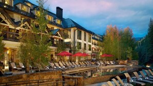 A resort with outdoor seating, a pool, and a mountain backdrop. - Westhaven 3 Bedroom Luxury Condo in Cascade Village, Steps to Chair Lift (Vail)