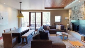 A spacious living area with a dining table, sofas, and a fireplace. - Westhaven 3 Bedroom Luxury Condo in Cascade Village, Steps to Chair Lift (Vail)