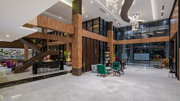 A spacious lobby with a staircase, seating areas, and a large chandelier. - EASTERN HOTEL BOJONEGORO (Bojonegoro)