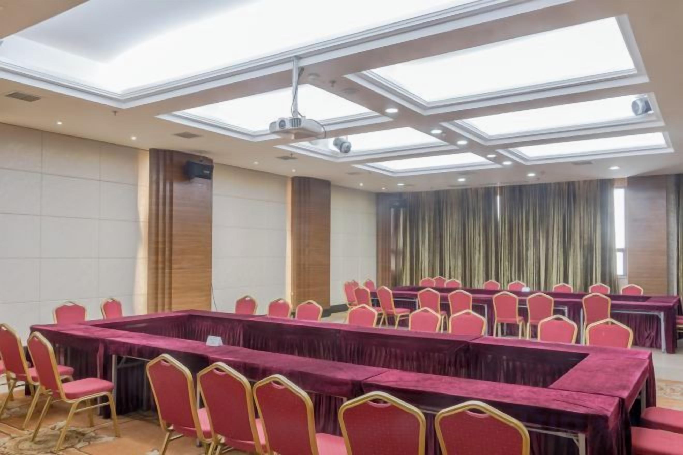 A conference room with a long table, multiple chairs, and a ceiling with skylights.