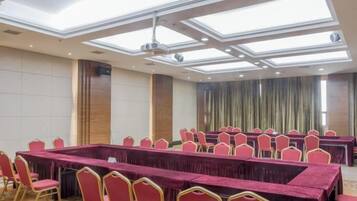 A conference room with a long table, multiple chairs, and a ceiling with skylights.