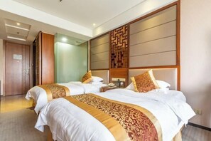 Une chambre d’hôtel avec deux lits, une tête de lit en bois, une table de chevet et une porte.