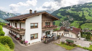 Un bâtiment à deux étages doté de balcons, d’un patio et offrant une vue sur une vallée verdoyante.