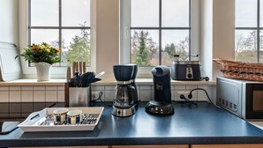 A kitchen with a coffee maker, a microwave, and a basket on the counter. - Apartment Krakow am See with Terrace & Wi-Fi (Krakow am See)