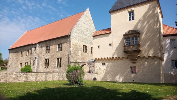 A historic building with a stone facade, a red-tiled roof, and a prominent tower. - Apartment 'Haus Am Markt 3' with Private Terrace and Wi-Fi (Schöningen)