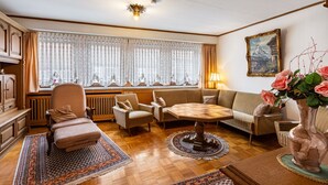A living room with a sofa, armchairs, a table, a radiator, and a window with curtains. - Apartment 'Haus Am Markt 3' with Private Terrace and Wi-Fi (Schöningen)
