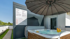 Un bain à remous, deux verres de jus d’orange, un patio abrité et un panneau avec des instructions.