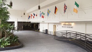 A spacious entrance area with a modern design, featuring a metal railing and a sign for Coronado Beach Resort.