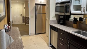 A modern kitchen with stainless steel appliances, a dishwasher, and a coffee maker.