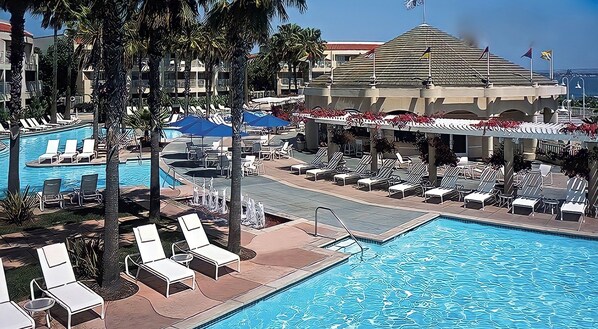 A poolside area at Loews Coronado Bay Resort with lounge chairs and umbrellas.