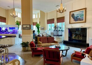 Eine großzügige Lobby mit einem großen Aquarium, bequemen Sitzgelegenheiten und einem Kamin.