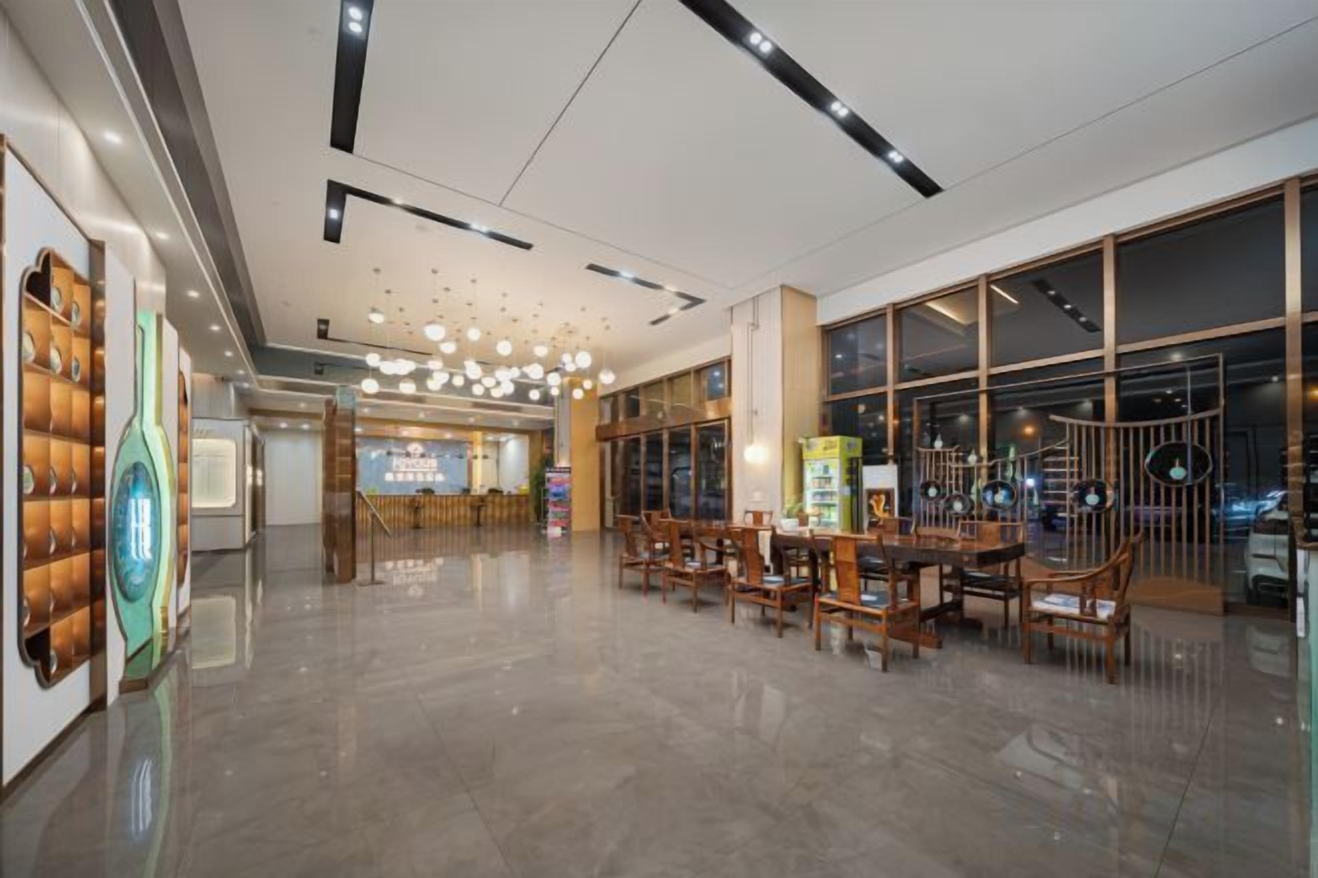 Un hall d’entrée spacieux au design moderne, comprenant un espace d’accueil, des coins salon et de grandes fenêtres.
