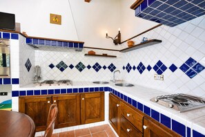 A kitchen with wooden cabinets, a stove, and a sink. - Casa Lella, Furore, Italy (Furore)