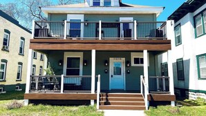 A two-story building with a balcony on the second floor, a front door, and a small porch area. - Trendy and Stylish 3BR Uptown Unit (Minneapolis)