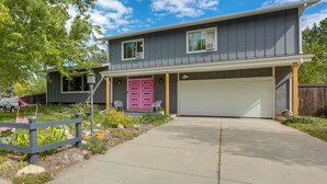 Une maison à deux étages avec un garage, un porche à l’avant et un petit jardin.