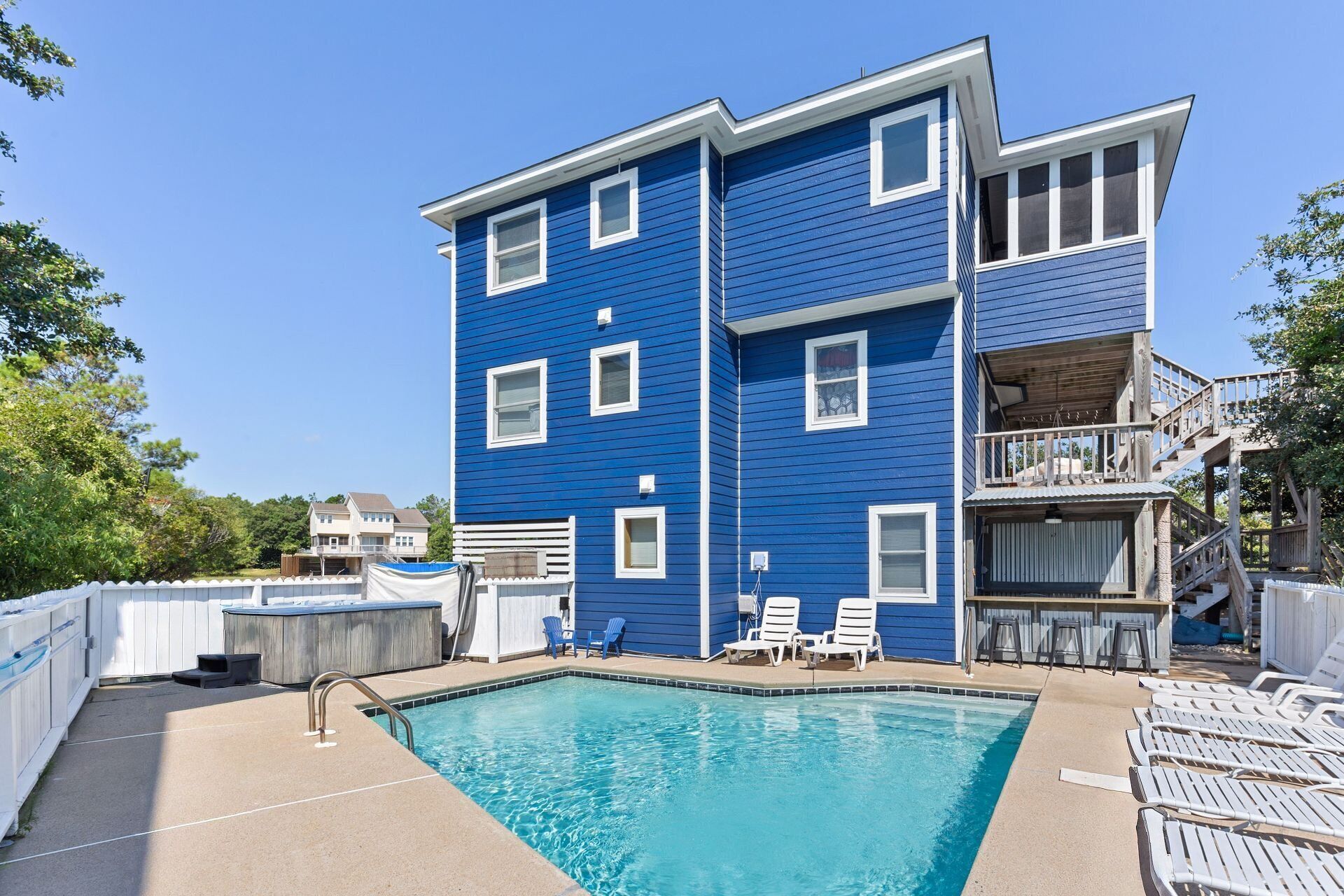 A two-story building with a pool and outdoor seating.