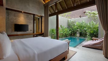Un dormitorio con cama, televisión y vistas a una piscina y jardín.