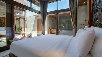 Ein modernes Hotelzimmer mit einem großen Bett, einem Holzkopfteil und großen Fenstern mit Blick ins Freie.