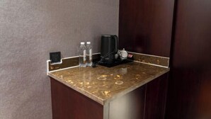 A marble countertop with a coffee maker, two water bottles, and a power outlet. - Zhenfeng Fangzhou Hotel (Zhenfeng)