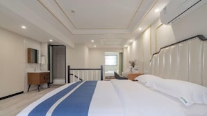 Een hotelkamer met een groot bed, een nachtkastje, een spiegel en een raam.