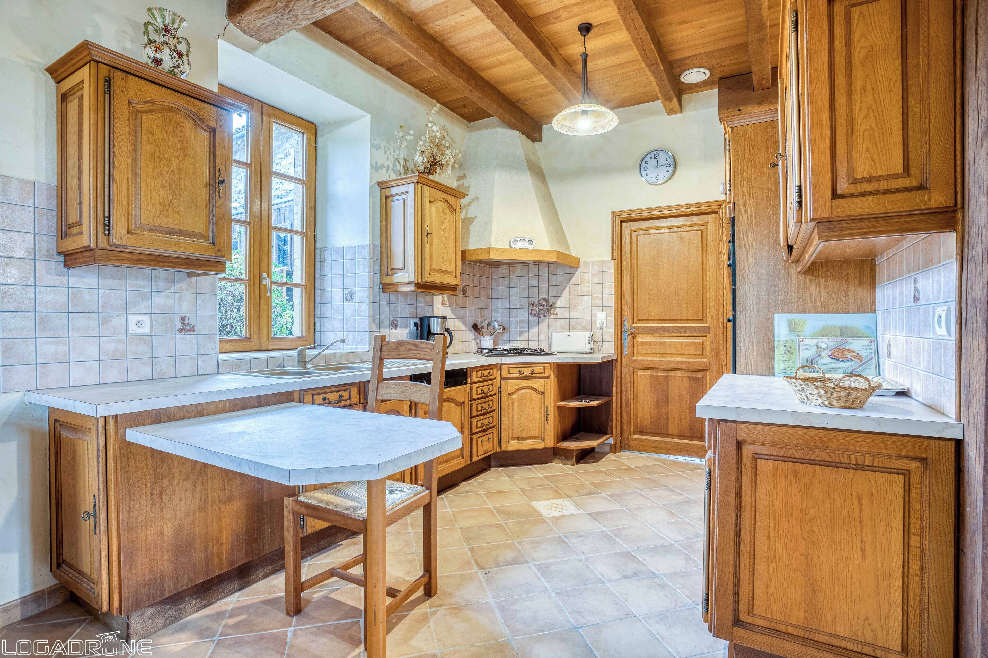 A kitchen with wooden cabinets, a tiled backsplash, and a stone countertop.