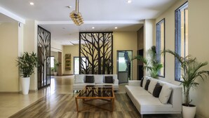Un salón amplio con un sofá blanco, una mesa de centro y plantas en macetas.