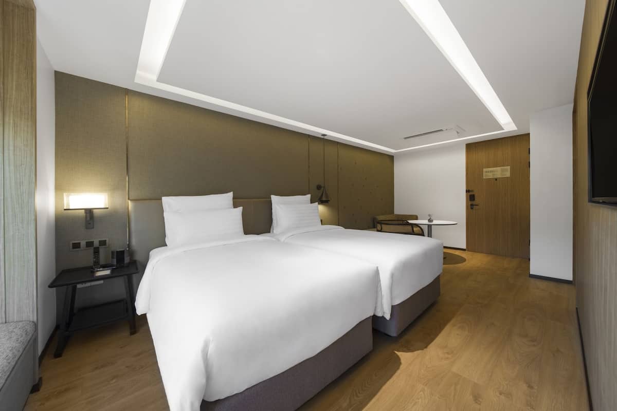 Une chambre d’hôtel moderne avec un grand lit, un bureau et une petite table.
