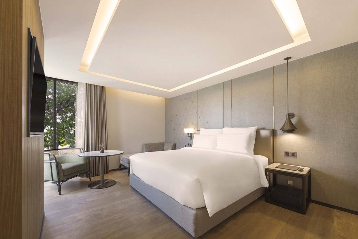 Une chambre d’hôtel moderne équipée d’un grand lit, d’un bureau, d’une chaise et d’une télévision.