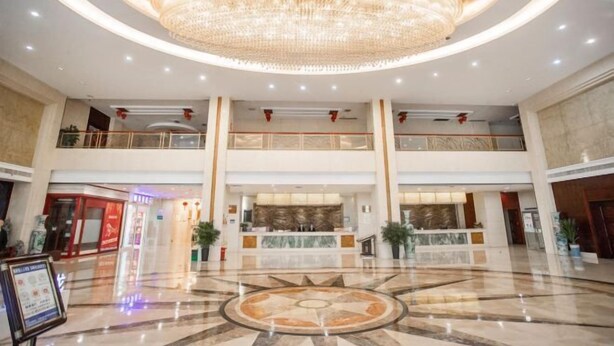 A spacious lobby with a large chandelier, a reception desk, and a circular floor design. - Nantian Hotel (Shangli)