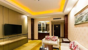 A modern living room with a flat-screen TV, a sofa, a coffee table, and a cabinet. - Nantian Hotel (Shangli)