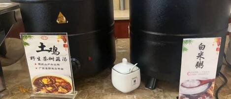 Two black containers with lids, a small white pitcher, and two informational signs with Chinese text.