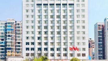 Un edificio de gran altura con varios pisos, probablemente un hotel o edificio de oficinas, con fachada uniforme y una serie de ventanas.