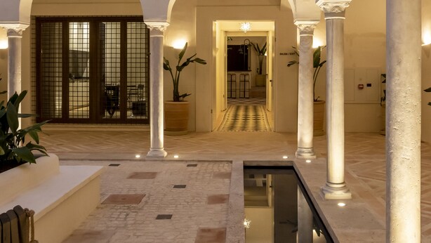 A spacious courtyard with a pool, columns, and arches. -  Casa del Rey Sabio (Seville)