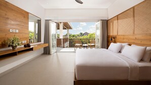 A modern bedroom with a large bed, a wooden headboard, a balcony with a view, and a ceiling fan. - Villa Christie by Nakula (Seminyak)