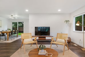 Relax in a comfortable living space with a large TV, dining area, and natural views.